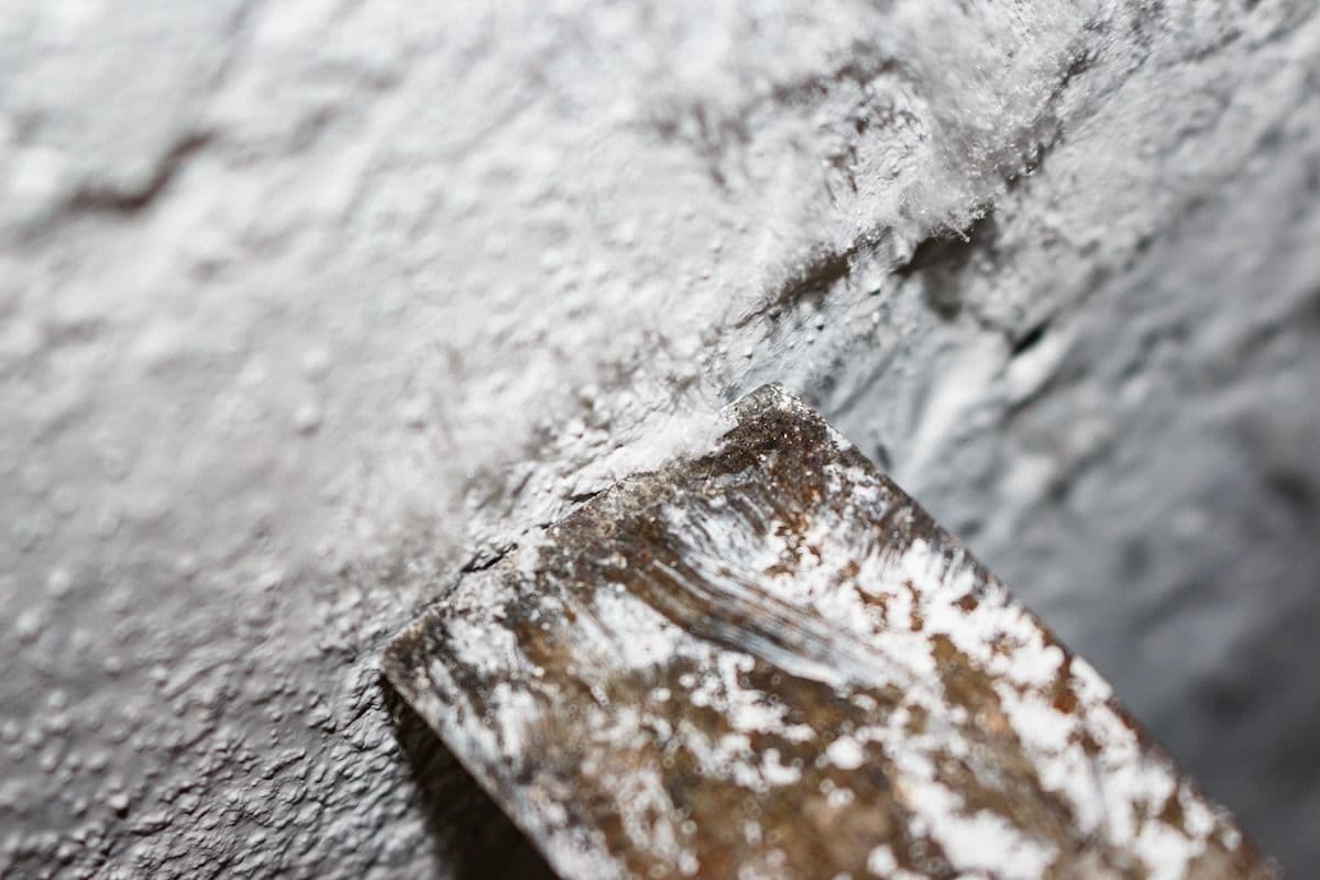 Paintbrush covered in white paint resting on a white painted surface