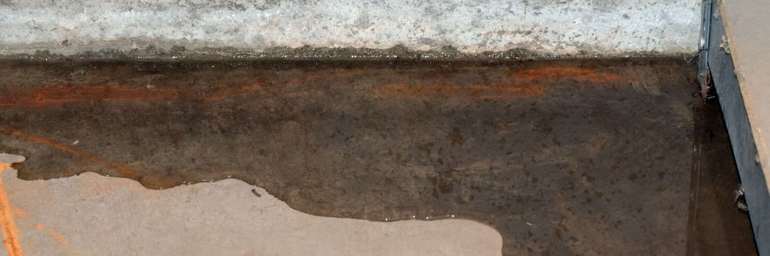 Rusted metal surface with heavy corrosion and orange oxidation, showing deterioration and water damage