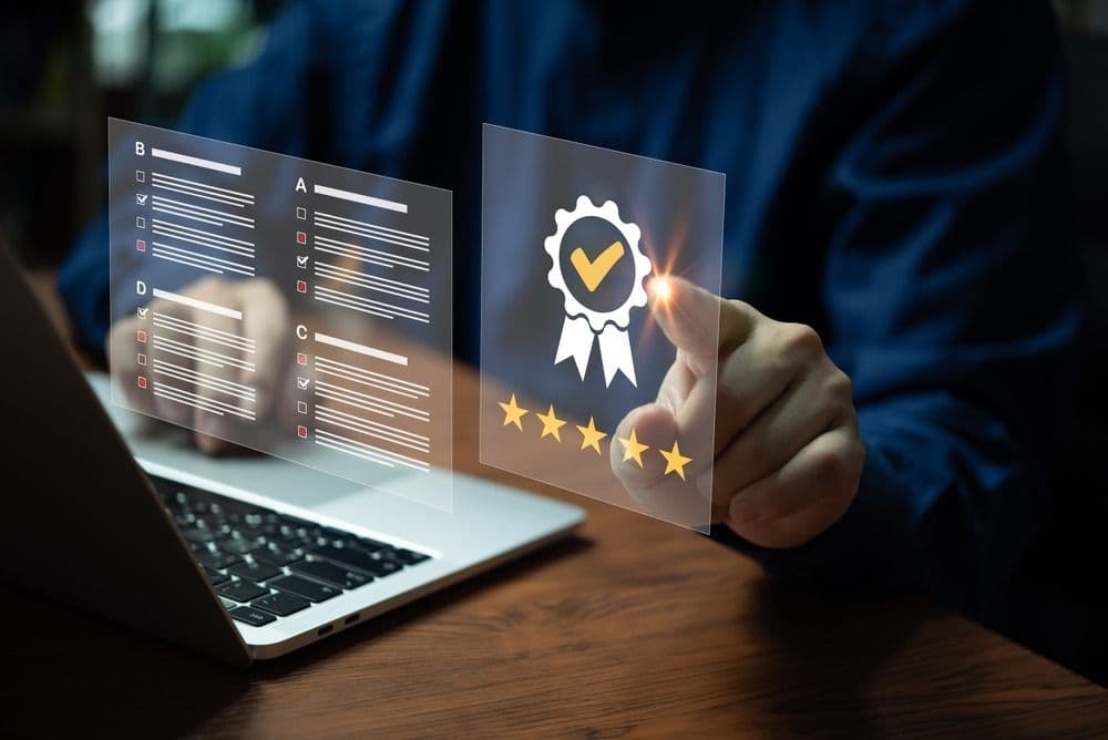 Person holding transparent screens showing quality checklist and certification badge with five stars rating above laptop