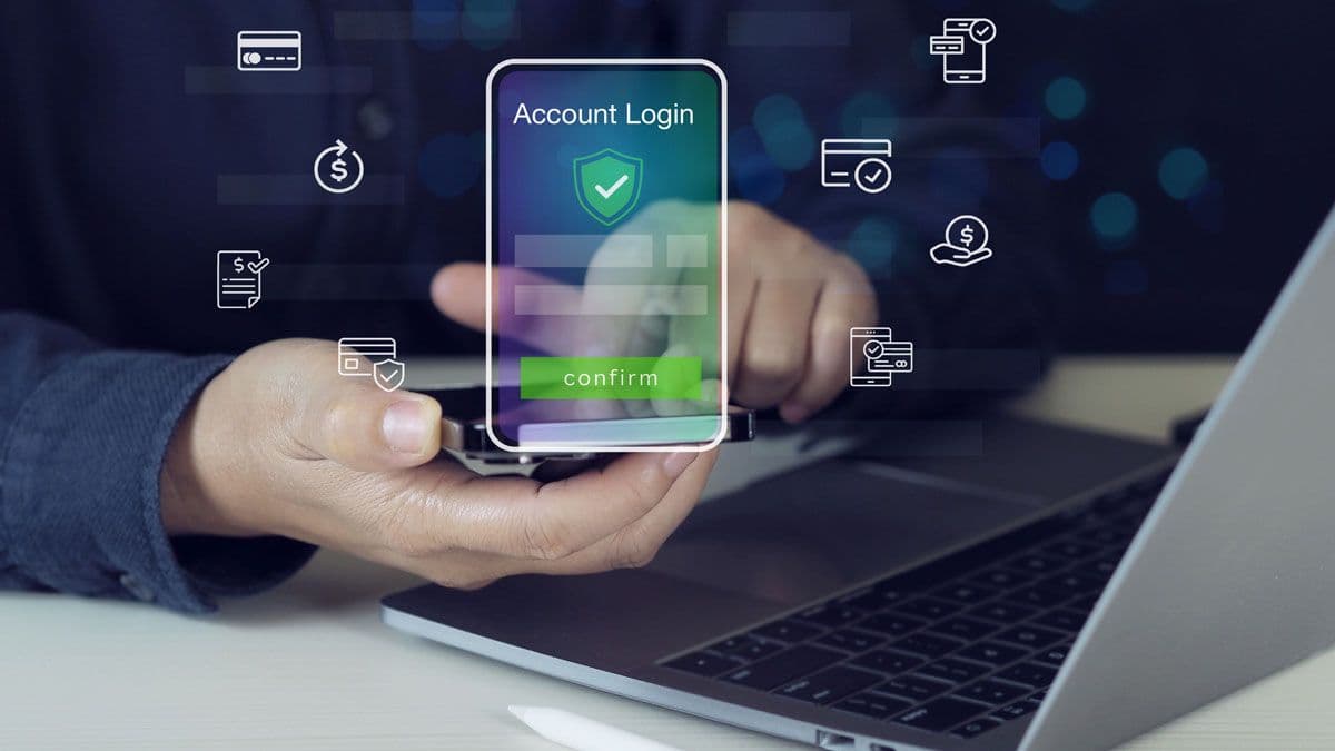 Hand holding smartphone displaying Account Login screen with security shield and confirm button, surrounded by financial and payment icons.